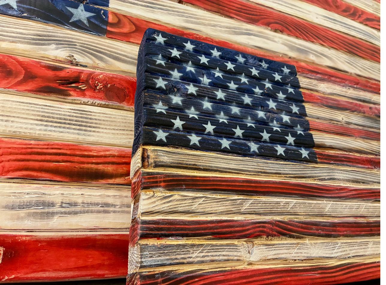 Close-up of hand-painted white stars on the blue canton of a wood American flag
